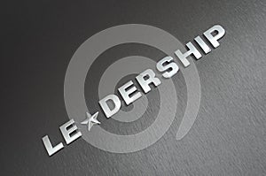 Concept of leadership, leader, motivation and guidance. Word leadership spelled on aluminium background