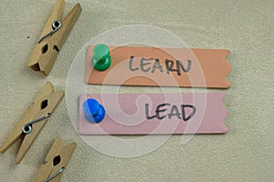 Concept of Learn and Lead write on sticky notes isolated on Wooden Table