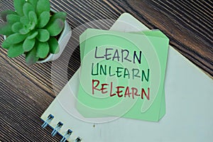 Concept of Learn, Unlearn, Relearn Continuous Learning write on sticky notes isolated on Wooden Table photo