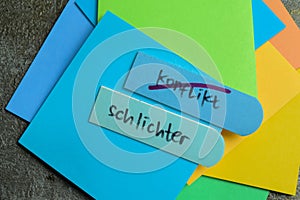 Concept of Learning language - German. Konflikt or schlichter it means Conflict or simpler written on sticky notes. German photo