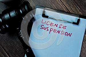 Concept of License Suspension write on paperwork with gavel isolated on Wooden Table