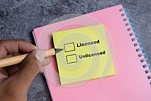Concept of Licensed or Unlicensed write on sticky notes  on Wooden Table