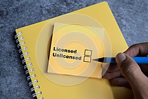 Concept of Licensed or Unlicensed write on sticky notes  on Wooden Table