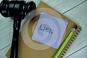 Concept of Lien write on sticky notes with gavel isolated on Wooden Table photo
