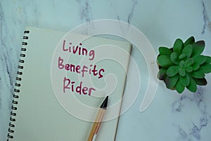 Concept of Living Benefits Rider write on a book isolated on Wooden Table