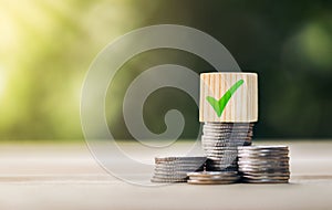 Concept of a loan approved to reduce debt and family expenses:  wooden block approval symbols placed on a pile of coins. approved