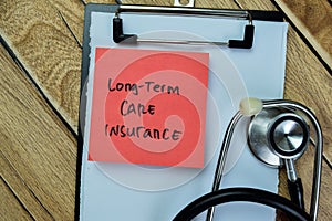 Concept of Long-term Care Insurance write on sticky notes isolated on Wooden Table