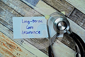 Concept of Long-Term Care Insurance write on sticky notes with stethoscope isolated on Wooden Table