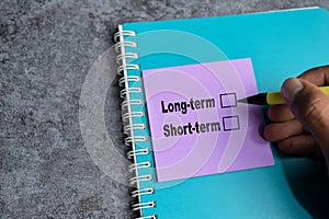 Concept of Long-term or short-term write on sticky notes  on Wooden Table