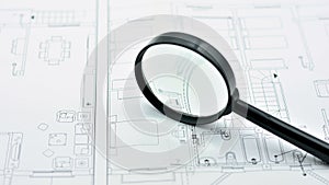 Concept of looking at a blueprint with a magnifying glass photo
