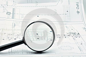 Concept of looking at a blueprint with a magnifying glass photo