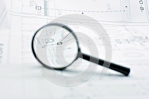 Concept of looking at a blueprint with a magnifying glass photo