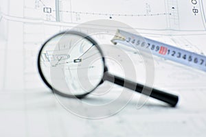 Concept of looking at a blueprint with a magnifying glass photo