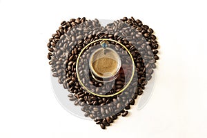 The concept of love for coffee, coffee mania. Roasted coffee beans laid out in the shape of a heart on a white