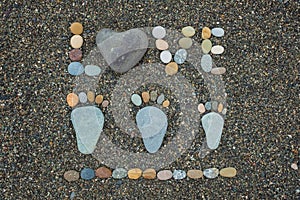 Family steps and word love made from stones on sandy beach.