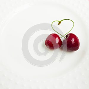 The concept of love - heart from berries of a sweet cherry.Isolated cherry. Heart shape from two cherries isolated white