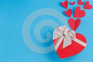 Concept for love stories and for Valentine`s Day. The inscription `Love`, hearts and a box in the form of a heart on a blue backgr
