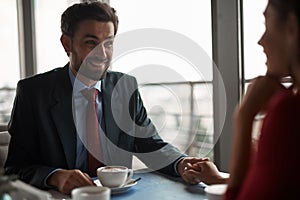 Smiling man and woman having meeting in restaurant