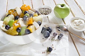 The concept of low-calorie delicious desserts. Fruit salad bowl with colorful fruits. Healthy natural organic food