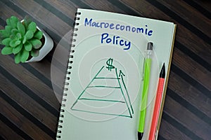 Concept of Macroeconomic Policy write on a book isolated on Wooden Table photo