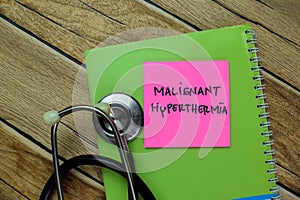 Concept of Malignant Hyperthermia write on sticky notes with stethoscope isolated on Wooden Table