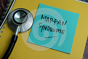 Concept of Marfan Syndrome write on sticky notes with stethoscope isolated on Wooden Table photo