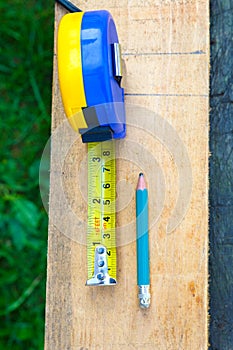The concept of measuring work in construction with wood material. Vertical photography