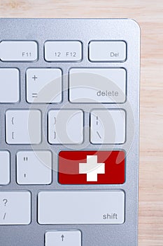 The concept of medical care online. Cross on the keyboard button. Top view. Vertical