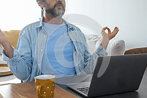 Concept of meditation and relaxation during online work with computer. Stress and problems on business job. One man doing yoga