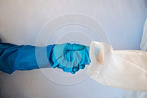 Concept of meeting between doctors. Close-up photo Male and female hands with gloves greeting each other with a handshake