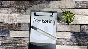 Concept of Mentoring write on paperwork isolated on Wooden Table