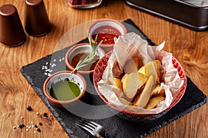 The concept of Mexican cuisine. Baked spicy potatoes with pepper, with different sauces, salsa, guacamole, chilli and shrimp.