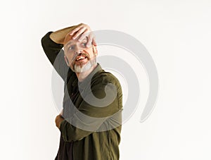 Concept of middle age crisis. Senior man standing against white wall. Mid aged man in pensive pose and looks into future