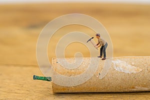 Concept miniature people destroying a Firecracker