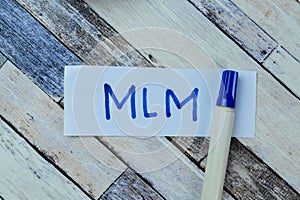 Concept of MLM write on sticky notes isolated on Wooden Table