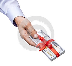 Concept, money as a gift, win or bonus. Man`s hand in shirt takes or gives pile of 100 dollar bills tied with red ribbon with bow