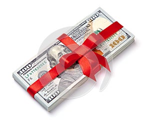 Concept, money as gift, win or bonus. Pile of 100 dollar bills is tied with red ribbon with bow. Isolated on white