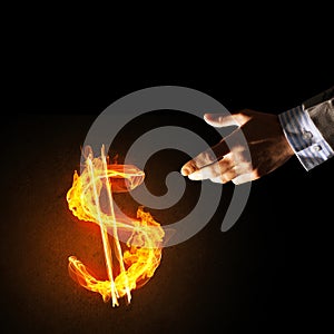 Concept of money making with dollar currency fire symbol on dark background