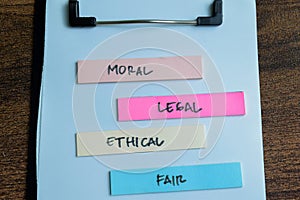 Concept of Moral, Legal, Ethical, Fair write on sticky notes isolated on Wooden Table