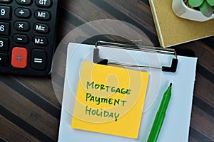 Concept of Mortgage Payment Holiday write on sticky notes isolated on Wooden Table