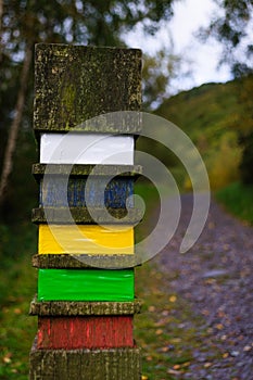 Concept of moving forwards: wooden post next to a footpath photo