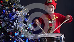 Concept of music. Happy Caucasian childish drummer in striped T-shirt and sunglasses plays on new drum set with drum sticks