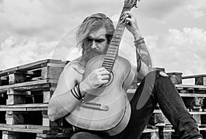 concept of music and vocal. man playing the acoustic guitar. brutal man with moustache and beard hold guitar. ranch guy