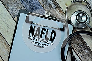 Concept of NAFLD - Non-Alcoholic Fatty Liver Disease write on paperwork with stethoscope isolated on Wooden Table photo