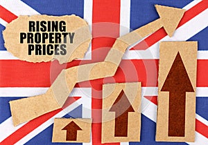 On the flag of Great Britain, a growth chart and a cardboard plate with the inscription - Rising property prices