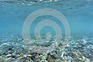 The concept of natural backgrounds and textures, desktop wallpaper. Pebble bottom and clear water of the Aegean Sea.