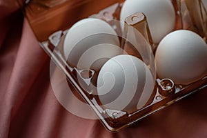 Concept of natural eggs. A tray of eggs on a pink background. eco tray with testicles. minimalistic trend, top view