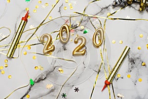 The concept of the new 2020 and Christmas. Gold numbers 2020, spangles and garlands on a marble background. top view, flat lay