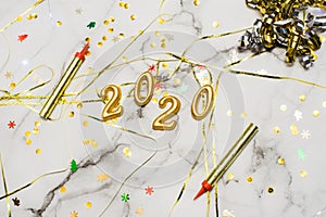 The concept of the new 2020 and Christmas. Gold numbers 2020, spangles and garlands on a marble background. top view, flat lay