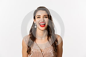 Concept of New Year celebration and winter holidays. Close-up of happy young woman dressed for party, laughing and